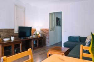 a living room with a couch and a tv at Cozy place next to Park Güell in Barcelona