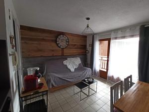 een slaapkamer met een bed en een klok aan de muur bij Le Repaire de Bellevaux aux pieds des pistes Haute Savoie in Bellevaux