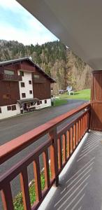 een balkon met uitzicht op een gebouw en een weg bij Le Repaire de Bellevaux aux pieds des pistes Haute Savoie in Bellevaux