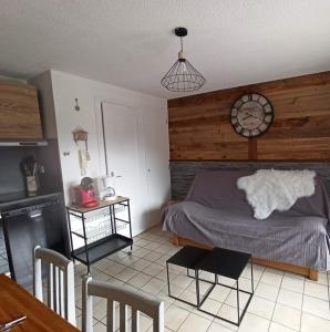 um quarto com uma cama e um relógio na parede em Le Repaire de Bellevaux aux pieds des pistes Haute Savoie em Bellevaux