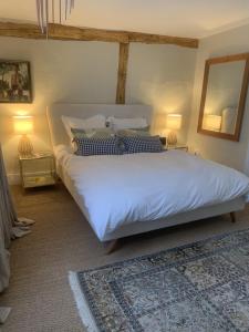 een slaapkamer met een groot wit bed met 2 lampen bij Blythe Cottage in Long Melford
