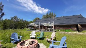 a group of chairs sitting around a fire pit at Raistiko Talu- Farmhouse, off-grid cabin and more in Punaküla