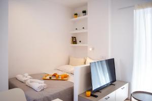 a living room with a tv and a bed at Stylish Modern Studio, Chalkida centre, seaside in Chalkida