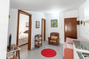 Sala de estar con dormitorio con cama y TV en Ático en Portonovo 200m de la Playa. + WIFI, en Portonovo