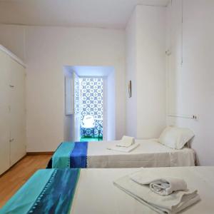 two beds in a room with a window at Residence Pé na Areia in Albufeira