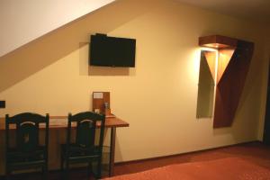 a dining room with a table and a tv on a wall at Hotel Kuźnia Oberża Polska in Łysomice +24 photos