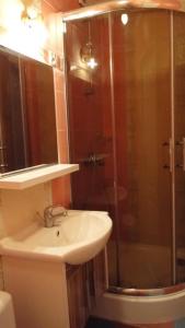 a bathroom with a sink and a glass shower at Pokoje gościnne U Wandy in Ostrowo +11 photos