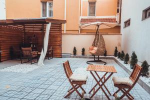 a patio with chairs and a table and an umbrella at VIP apartments Bitola in Bitola