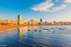 Un grupo de barcos en el agua cerca de una playa. en LuxuryFlats La Isleta - 2BR - Balcony - Parking - Beach, en Las Palmas de Gran Canaria