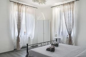 - une chambre blanche dotée d'un lit avec des chaussures dans l'établissement Casa La Fortezza, à Livourne