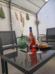 een glazen tafel met twee wijnflessen en wijnglazen bij La Perla in Francavilla Fontana