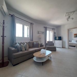a living room with a couch and a coffee table at Jerrys Home Agios Petros in Áyios Pétros
