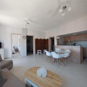 a living room with a table and a kitchen at Jerrys Home Agios Petros in Áyios Pétros
