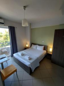 a bedroom with a bed and a table and a window at Peania Domus in Paianía