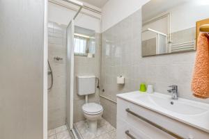 een witte badkamer met een toilet en een wastafel bij Matea Rooms in Funtana