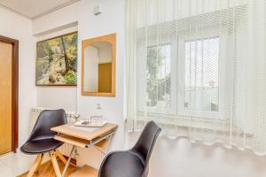 een eetkamer met een tafel en 2 stoelen en een raam bij Matea Rooms in Funtana