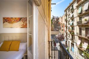 uma varanda com uma cama e vista para um edifício em CENTRIC APARTMENT GAUDI em Barcelona