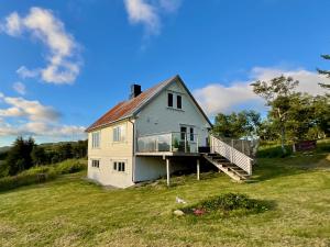 a white house with a porch and a deck at Leknes Panorama Lofoten in Leknes