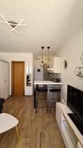 een keuken en een woonkamer met een tafel en een plafondventilator bij Studio apartman Kiara in Bol