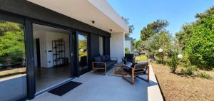 マリ・ロシニにあるHoliday house Manokaの家の上に机と椅子が付いたポーチでスクリーン