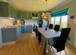 a kitchen and dining room with a table and chairs at Leknes Panorama Lofoten in Leknes