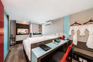 a hotel room with a bed and a desk at Vib Best Western Sanam Pao in Bangkok