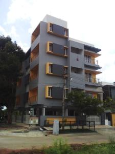 a tall apartment building with a lot of windows at The Vihar service Apartment in Mysore