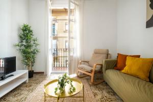 a living room with a couch and a tv at CENTRIC APARTMENT GAUDI in Barcelona