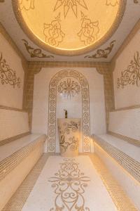 une pièce vide avec un plafond doré et un miroir dans l'établissement Konstantin Plaza, à Samarcande
