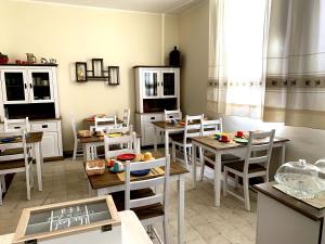 Domo Achenza في Terralba: غرفة طعام مع طاولات وكراسي بيضاء