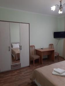 1 dormitorio con cama, escritorio y espejo en Готель Баронський Двір, en Chernivtsi