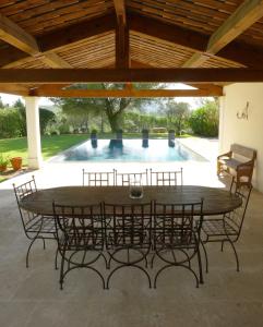 a table and chairs in a patio with a pool at La Tour D'Orgueil in Mallemort