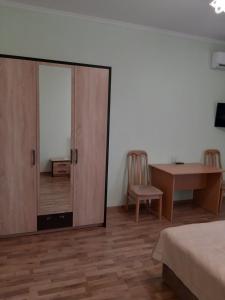 a bedroom with a sliding glass door with a table and chair at Готель Баронський Двір in Chernivtsi