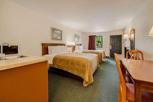 Una habitación de hotel con dos camas y un lavabo. en Rodeway Inn Sandersville, en Sandersville