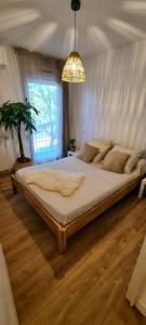 a large bed in a bedroom with a chandelier at Appartement avec terrasse, parking et proche tramway in Montpellier