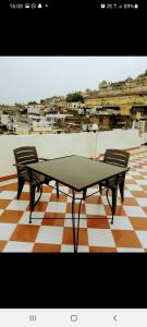 uma mesa de pingue-pongue e duas cadeiras no chão em Nandini Paying Guest House em Udaipur