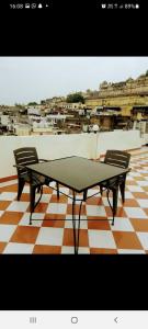 een tafeltennistafel en 2 stoelen op een vloer bij Nandini Paying Guest House in Udaipur
