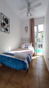 1 dormitorio con 1 cama y ventilador de techo en Agradable adosado cerca de la playa en Benicàssim