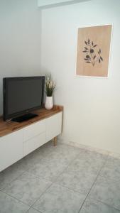 een woonkamer met een televisie op een dressoir bij Lovely apt near the beach in Athene