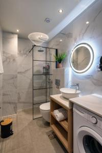 a bathroom with a toilet and a sink and a washing machine at Deluxe Suites Irianna - in the heart of Old Town in Heraklio