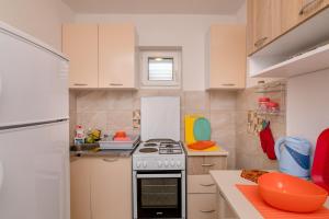 a kitchen with white cabinets and a stove top oven at Apartments Mitrovic in Lustica