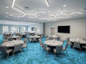 a conference room with tables and chairs and a screen at Hilton Garden Inn Visalia, Ca in Visalia