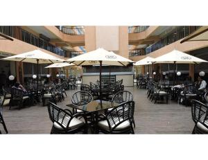 an empty restaurant with tables and chairs and umbrellas at Sky Hotel Nairobi in Nairobi