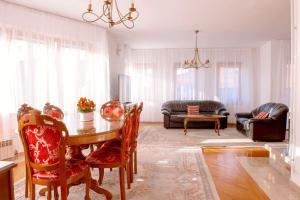una sala de estar con una mesa, sillas y un sofá en Engadin Apartments - Free Parking, en Sarajevo