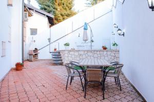 un patio con mesa y sillas en un suelo de ladrillo en Engadin Apartments - Free Parking, en Sarajevo