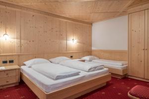 Ένα ή περισσότερα κρεβάτια σε δωμάτιο στο Hotel Residence Gardena Dolomites 2