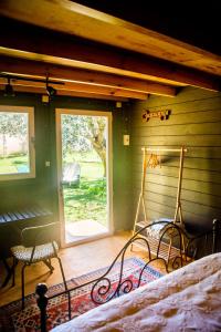 Schlafzimmer mit einer Veranda mit einem Bett und einem Fenster in der Unterkunft Figueirinha Ecoturismo in Montes da Estrada