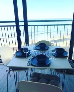 uma mesa com pratos e copos de vinho numa varanda em Penthouse Apartment with seaviews em Walton-on-the-Naze