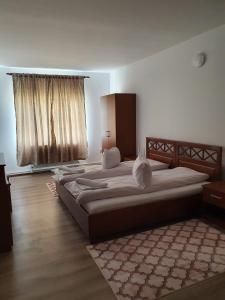 een slaapkamer met 2 bedden en een raam bij Pensiune Restaurant Cosna in Coşna