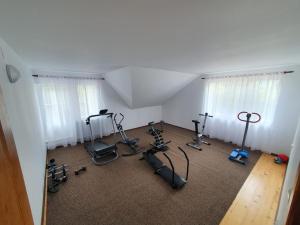 a gym with treadmills and exercise bikes in a room at Pensiune Restaurant Cosna in Coşna